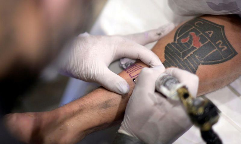 A fan of Brazilian team Atletico Mineiro gets a free tattoo offered by the company constructing the new stadium after the squad won the Brazilian Championship