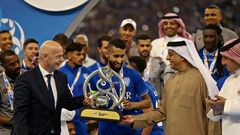 FIFA President Gianni Infantino (left) presents the trophy to Al Hilal midfielder Salman Al-Faraj