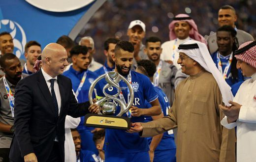 FIFA President Gianni Infantino (left) presents the trophy to Al Hilal midfielder Salman Al-Faraj