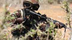 A Kenya Defence Forces (KDF) soldier, part of the African Mission in Somalia (AMISOM), secures an area during a foot patrol on the outskirts of the controlled area of the old airport in the coastal town of Kismayu in southern Somalia November 12, 2013....