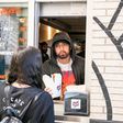 DETROIT, MICHIGAN - SEPTEMBER 29: Eminem serves Mom's Spaghetti to a fan on the opening night of his restaurant "Mom's Spaghetti" on September 29, 2021 in Detroit, Michigan. (Photo by Scott Legato/Getty Images)