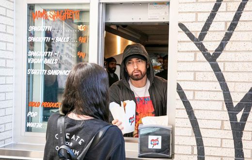 DETROIT, MICHIGAN - SEPTEMBER 29: Eminem serves Mom's Spaghetti to a fan on the opening night of his restaurant "Mom's Spaghetti" on September 29, 2021 in Detroit, Michigan. (Photo by Scott Legato/Getty Images)