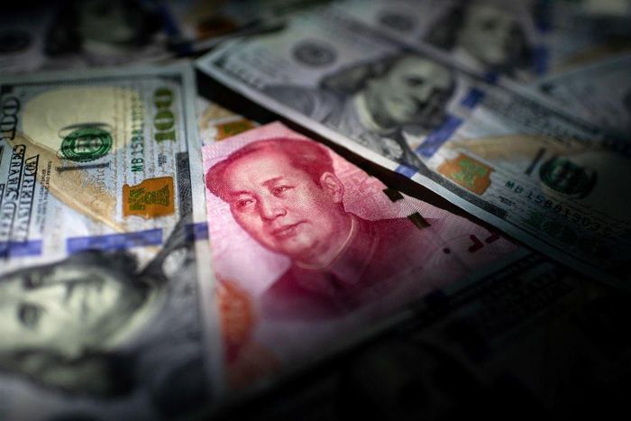 This photo illustration shows a Chinese 100 yuan note (C) and US 100 notes in Beijing on January 14, 2020.  (Photo by NICOLAS ASFOURI/AFP via Getty Images)