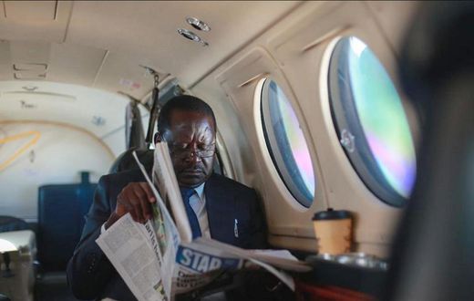 ODM leader Raila Odinga reading a newspaper in a plane