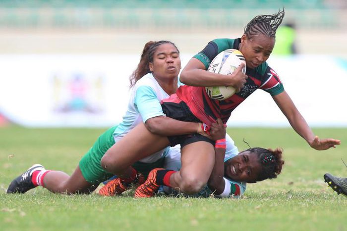 Madagascar players vie for the ball against Kenya's Terry Ayetsa (wearing red) during the Rugby Africa Women's Cup finals at Nyayo Stadium, Nairobi on July 11 2021.