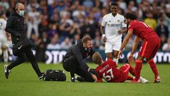 A trainer runs on the pitch to help Liverpool's Harvey Elliott (C)