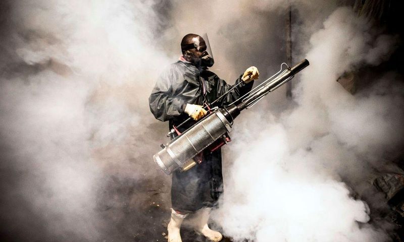 TOPSHOT - A member of a privately-funded NGO working with county officials wearing protective gear fumigates and disinfects on April 15, 2020, during the dusk-to-dawn curfew imposed by the Kenyan Government, the streets and the stalls at Parklands City...
