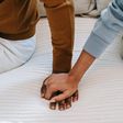 Couple holding hands on bed [Image: Alex Green]
