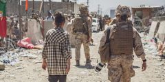 In this image provided by the U.S. Marine Corps, a Marine with Special Purpose Marine Air-Ground Task Force - Crisis Response - Central Command, escorts a young girl at an evacuation control checkpoint during an evacuation at Hamid Karzai International Airport in Kabul, Afghanistan, Thursday, Aug. 26, 2021.
