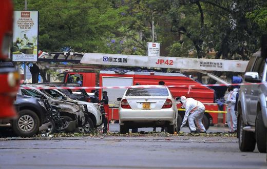 Security forces and forensics officers examine the scene of a blast on a street near the parliamentary building in Kampala, Uganda, Tuesday, Nov. 16, 2021. Two loud explosions rocked Uganda's capital, Kampala, early Tuesday, sparking chaos and confusio...