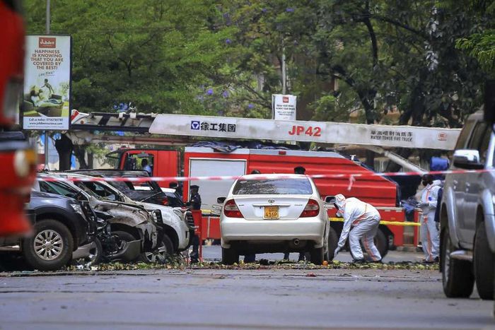 Security forces and forensics officers examine the scene of a blast on a street near the parliamentary building in Kampala, Uganda, Tuesday, Nov. 16, 2021. Two loud explosions rocked Uganda's capital, Kampala, early Tuesday, sparking chaos and confusio...