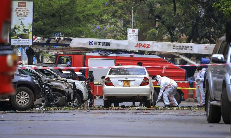 Security forces and forensics officers examine the scene of a blast on a street near the parliamentary building in Kampala, Uganda, Tuesday, Nov. 16, 2021. Two loud explosions rocked Uganda's capital, Kampala, early Tuesday, sparking chaos and confusio...