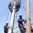 Kenya Power workers install concrete pole