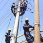 Kenya Power workers install concrete pole