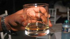 A person holding glass of alcohol