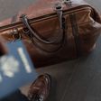 A man travelling with a brown leather duffel bag [Image: Nappy]
