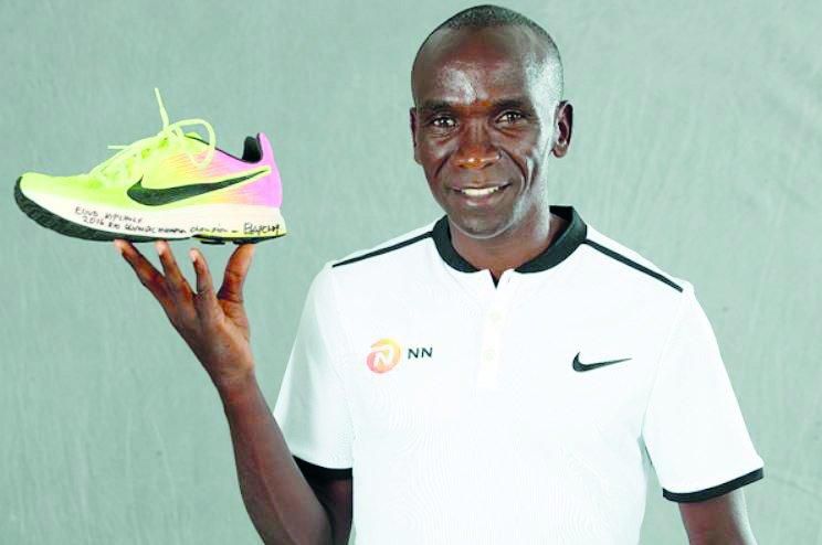Eliud Kipchoge with his Rio Olympic shoe which was first displayed at the 2019 IAAF Heritage World Athletics Championships Exhibition in Doha, Qatar.
