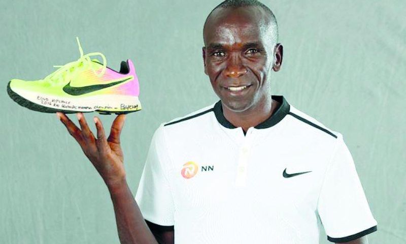 Eliud Kipchoge with his Rio Olympic shoe which was first displayed at the 2019 IAAF Heritage World Athletics Championships Exhibition in Doha, Qatar.