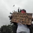 Protester holding placard in Nairobi which reads: "Colonialism never really ended. Corruption is as bad as colonialism."