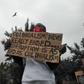 Protester holding placard in Nairobi which reads: "Colonialism never really ended. Corruption is as bad as colonialism."