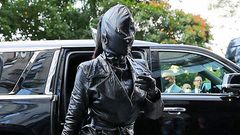 Kim Kardashian seen wearing a tied trench coat, leather pants and high heeled boots, along with a rhinestone “Hourglass” handbag. Photo by: Felipe Ramales / SplashNews.com