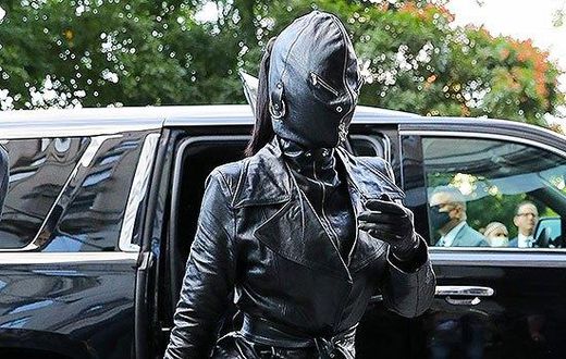 Kim Kardashian seen wearing a tied trench coat, leather pants and high heeled boots, along with a rhinestone “Hourglass” handbag. Photo by: Felipe Ramales / SplashNews.com