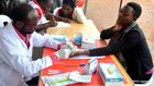 A World Health Organization worker draws a sample