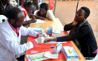 A World Health Organization worker draws a sample