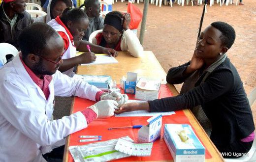 A World Health Organization worker draws a sample