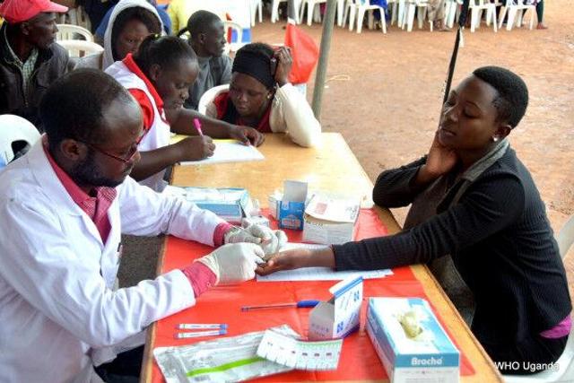 A World Health Organization worker draws a sample