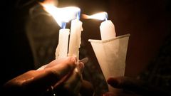 People hold candles as they pray during a candlelight vigil at the Immanuel Church for victims of the El Paso shooting