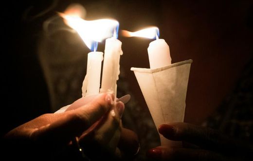 People hold candles as they pray during a candlelight vigil at the Immanuel Church for victims of the El Paso shooting