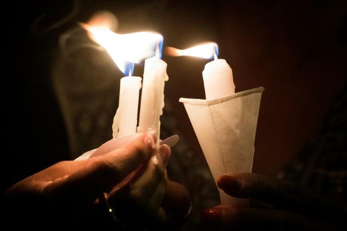 People hold candles as they pray during a candlelight vigil at the Immanuel Church for victims of the El Paso shooting
