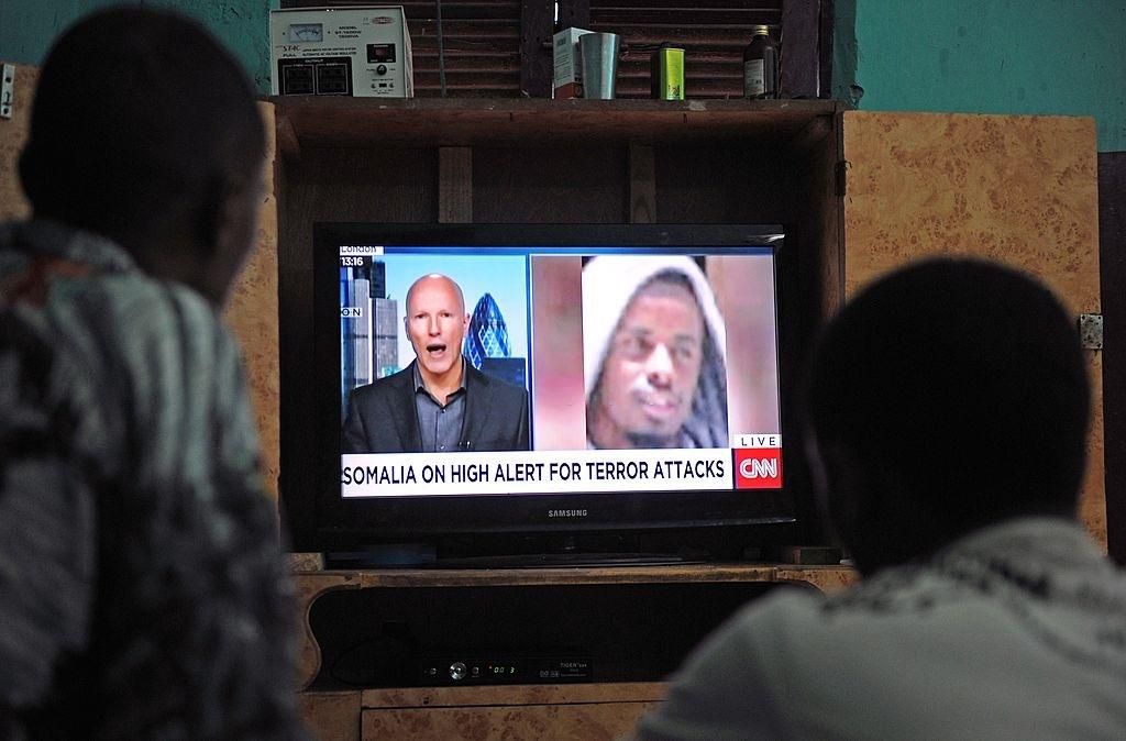 Somali men watch the news on September 6, 2014 in Mogadishu on a television set where is broadcasted a portrait of Somalia's Al-Qaeda-linked Shebab slain leader Ahmed Abdi Godane, recently killed in a US air strike. Somalia's Al-Qaeda-linked Shebab militants on September 6 announced the appointment of Godane's successor naming Ahmad Umar Abu Ubaidah, described by Shebab sources as a close lieutenant to Godane -- although the name is seen as likely to be a pseudonym. The group also vowed to avenge the death of Godane and said they would continue their fight to topple the country's internationally-backed government. AFP PHOTO / MOHAMED ABDIWAHAB (Photo credit should read Mohamed Abdiwahab/AFP via Getty Images)