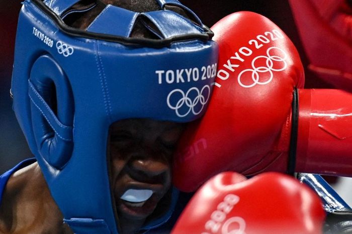 Kenya's Christine Ongare takes a punch from Philippines' Irish Magno during their women's fly (48-51kg) preliminaries boxing match during the Tokyo 2020 Olympic Games at the Kokugikan Arena in Tokyo on July 25, 2021. (Photo by Luis ROBAYO / POOL / AFP)...