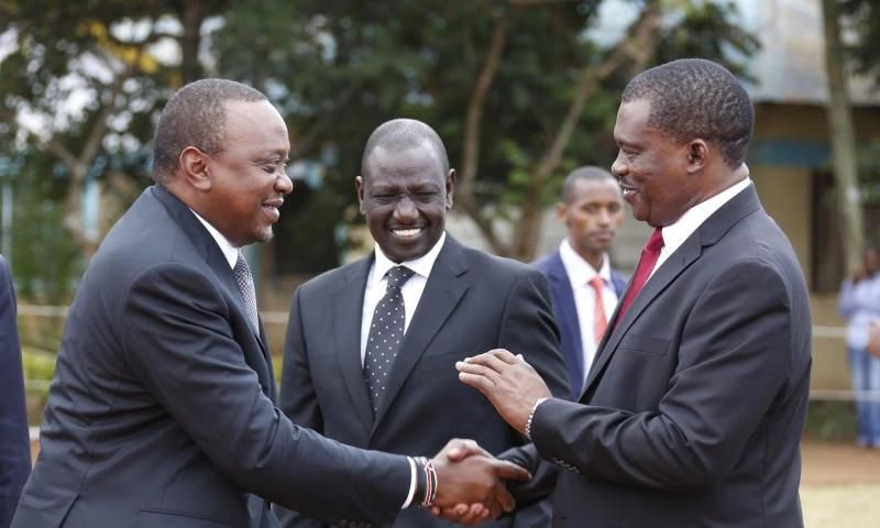 President Uhuru Kenyatta consoles National assembly speaker Justin Muturi during the burial service of the mother of National Assembly Speaker Justin Muturi in Embu County, looking on is DP WIlliam Ruto.