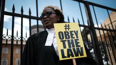 Kenyan lawyer and Law Society of Kenya's CEO Mercy Wambua holds a placard in front of the Supreme Court in Nairobi, on February 15, 2018 during a demonstration against impunity and disobedience of court orders. Kenya's Chief Justice on February 7 criti...