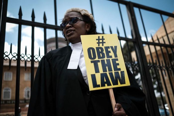 Kenyan lawyer and Law Society of Kenya's CEO Mercy Wambua holds a placard in front of the Supreme Court in Nairobi, on February 15, 2018 during a demonstration against impunity and disobedience of court orders. Kenya's Chief Justice on February 7 criti...