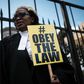 Kenyan lawyer and Law Society of Kenya's CEO Mercy Wambua holds a placard in front of the Supreme Court in Nairobi, on February 15, 2018 during a demonstration against impunity and disobedience of court orders. Kenya's Chief Justice on February 7 criti...