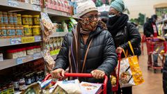 A woman wearing a mask moves her shopping cart December 3, 2020 in a Trader Joe's supermarket in New York City.