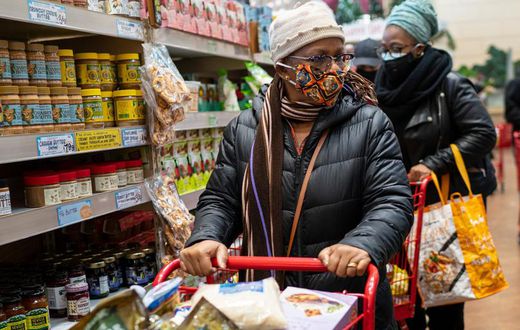A woman wearing a mask moves her shopping cart December 3, 2020 in a Trader Joe's supermarket in New York City.