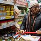 A woman wearing a mask moves her shopping cart December 3, 2020 in a Trader Joe's supermarket in New York City.