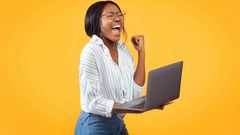 A person showing excitement while holding a laptop