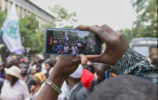 A photo of a person recording a video on their phone