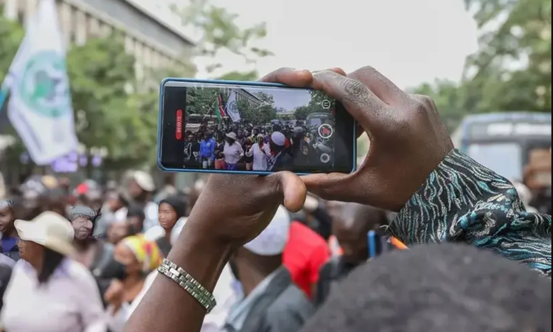 A photo of a person recording a video on their phone