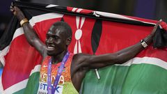 Emmanuel Wanyonyi hoists the Kenyan flag after a win