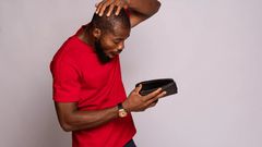 A man looking at his empty wallet