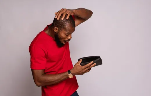 A man looking at his empty wallet