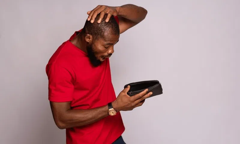 A man looking at his empty wallet