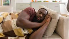 A man taking a nap on the couch